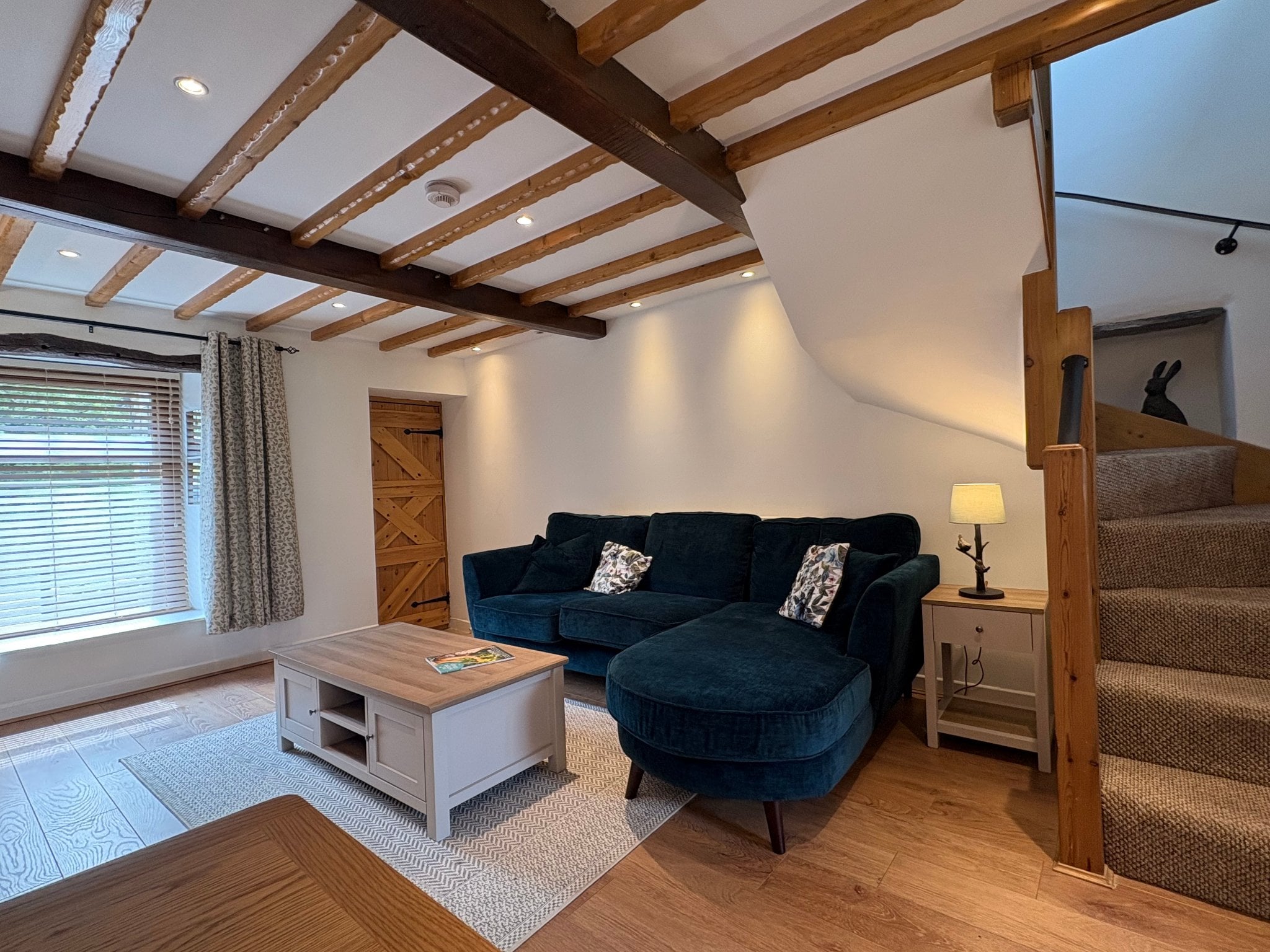 Warm cottage interior with a lit fireplace and comfortable seating